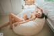 A woman laying on a bean bag chair in a bedroom.