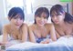 A group of three young women laying on top of a bed.