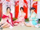 A group of three women in kimonos sitting on the ground.