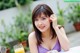 A woman sitting at a table with a glass of orange juice.