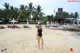 A woman in a black bathing suit standing on a beach.