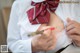 A woman in a white shirt and red bow tie holding a pencil.