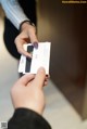 A person holding a business card in their hand.