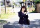 A woman in a school uniform is walking down the street.